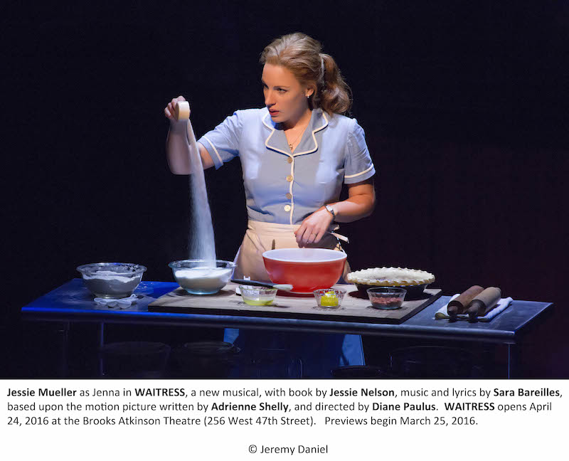 Jenna Mueller from the Waitress stands behind a table with pie ingredients.
